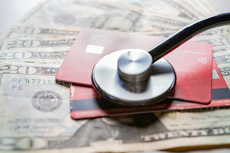 Stethoscope with bank notes and credit card. Stethoscope on credit card with dollar bills