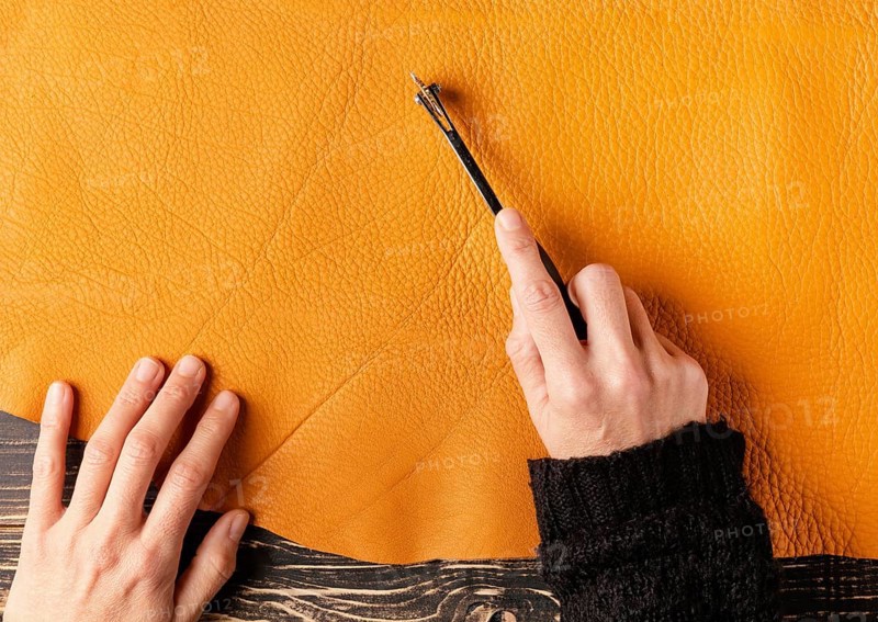 Close up hand cutting leather