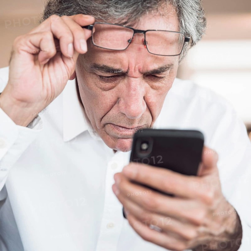 Close up serious senior man looking smart phone