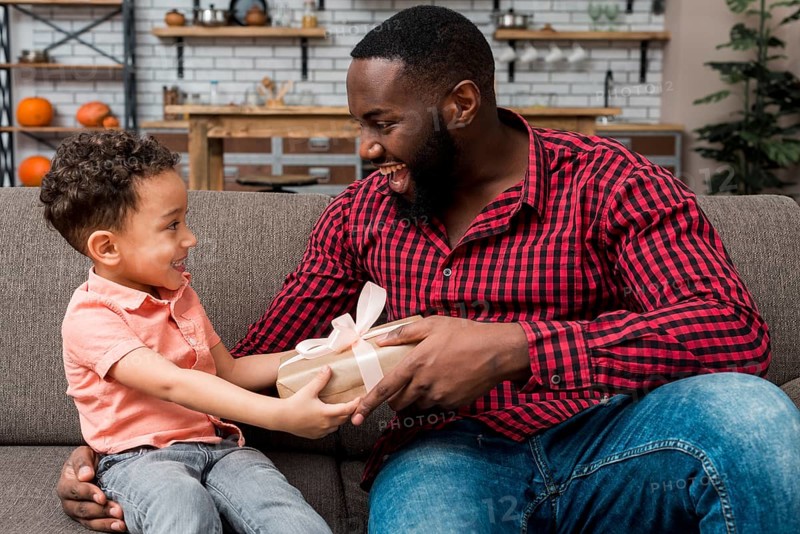 Black cute son giving gift father