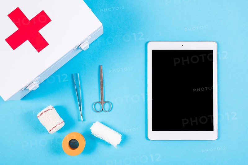 Medical equipments with first aid kit blank digital tablet blue background