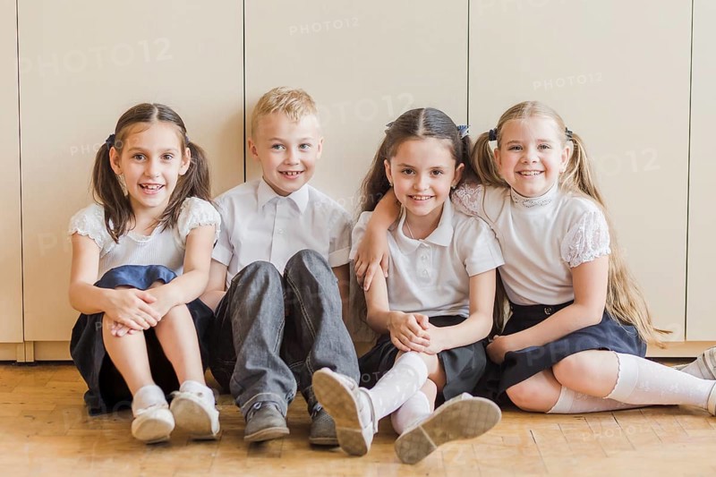 Cheerful kids sitting floor school