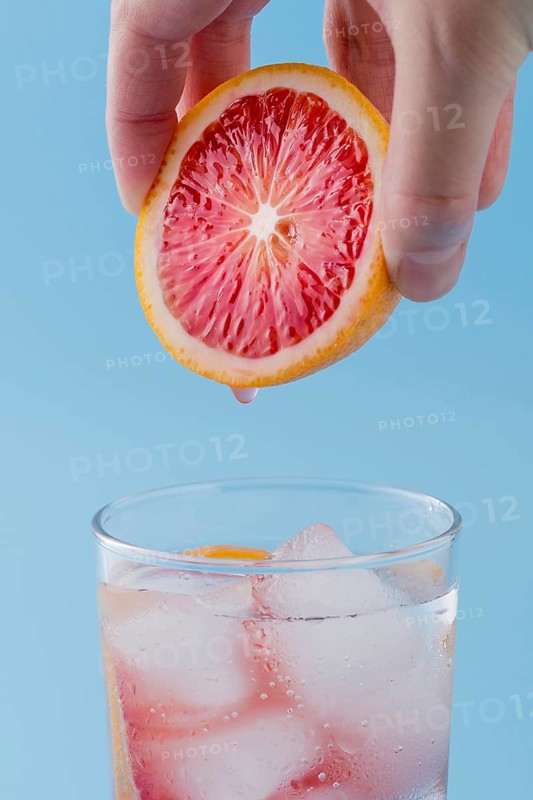 Close up man holding red orange slice