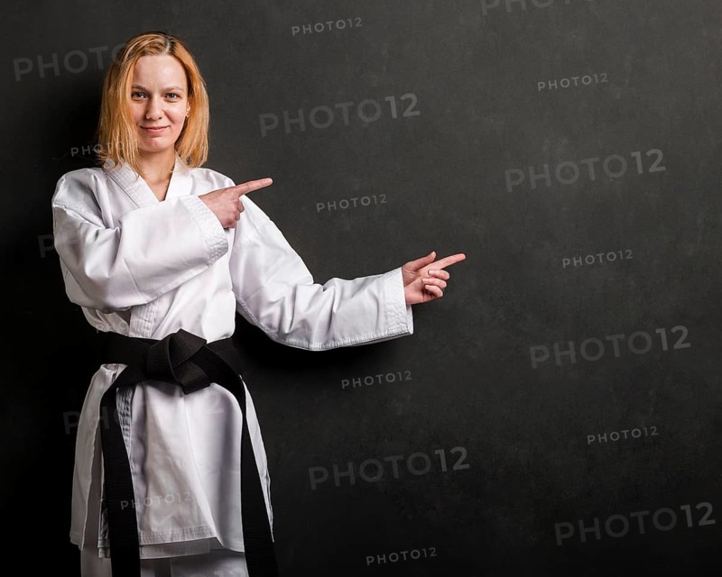 Karate fighter pointing copy space