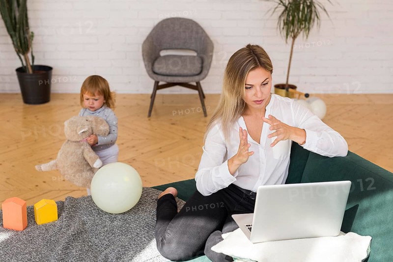 Full shot mother working from home