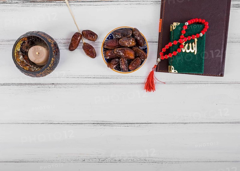 Juicy dried dates bowl candle diary kuran islamic rosary prayer beads white wooden desk