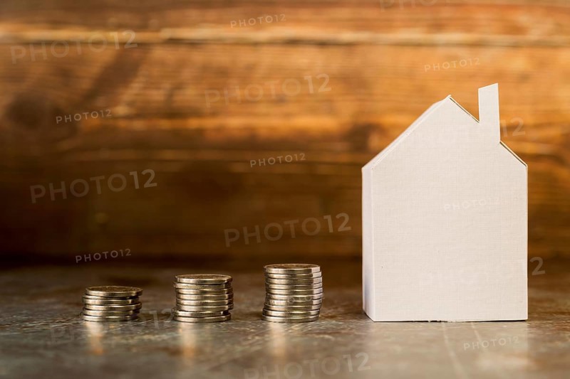 Increasing stack coins near paper house surface