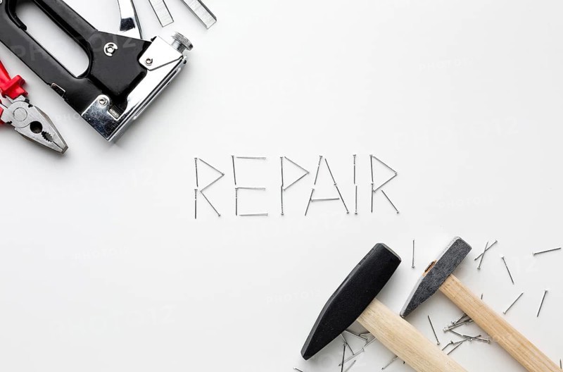 Hammers repair word written with nails