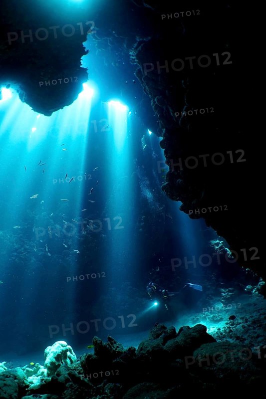 Diver swimming in cave