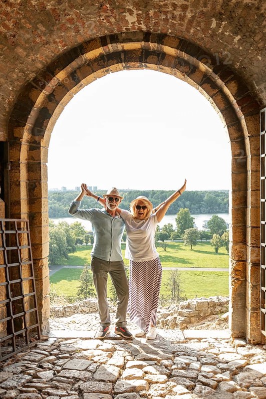 Couple raising their hands air front door