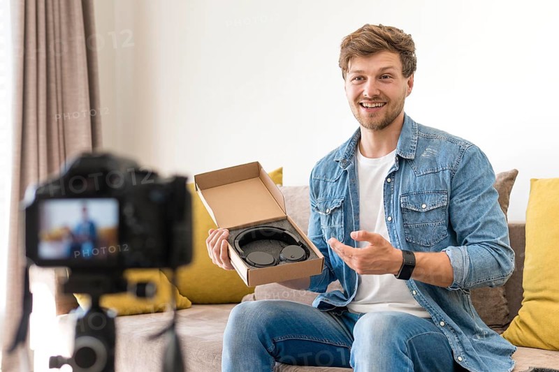 Handsome male recording unboxing video home