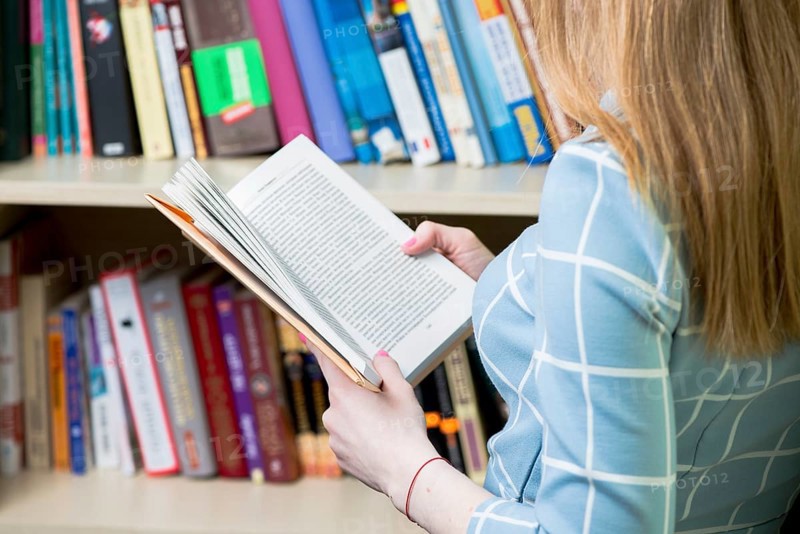 Close up girl reading book library