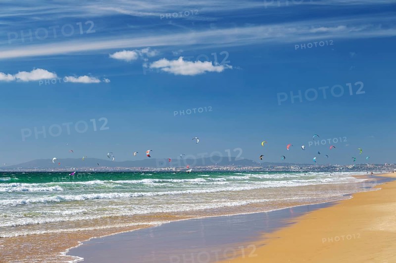 Kiteboarding kitesurfing kiteboarder kitesurfer kites on the Atlantic ocean beach at Fonte da Telha beach