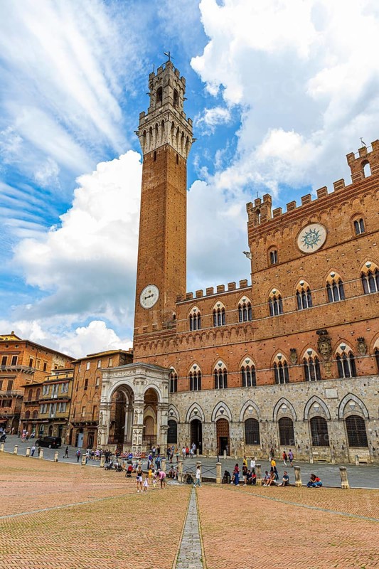 Atmospheric clouds at the Piazza del Campo with its bell tower Torre del Mangia and the town hall Palazzo Pubblico