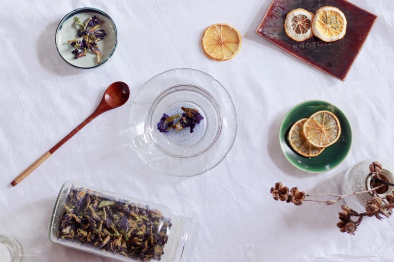 Overhead view of dried butterfly pea flowers or Clitoria ternatea and dried lemon slices for making herbal tea