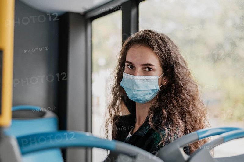 Woman with curly hair wearing medical mask bus