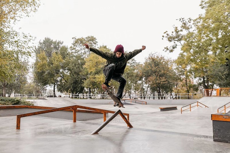 Man outside with skateboard park