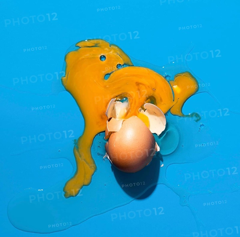 Top view broken egg blue background