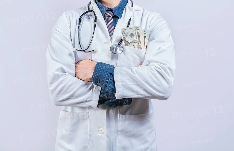 Corrupt doctor with bribe money in pocket isolated. Medical bribery concept. Bribed doctor with money in pocket isolated