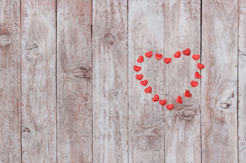 Corazones de peluche encima de una mesa de madera