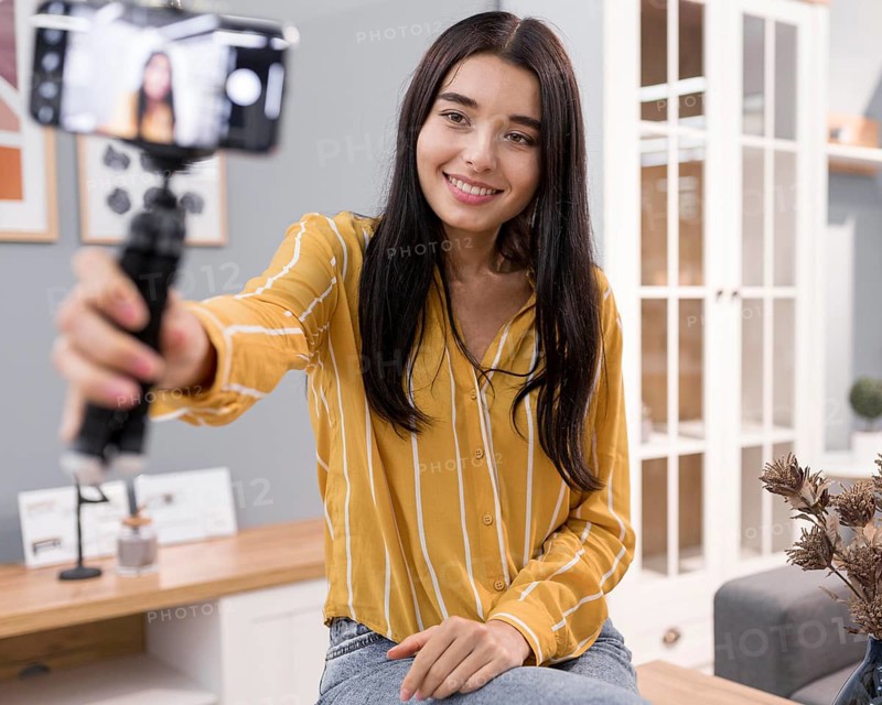 Female vlogger home with smartphone