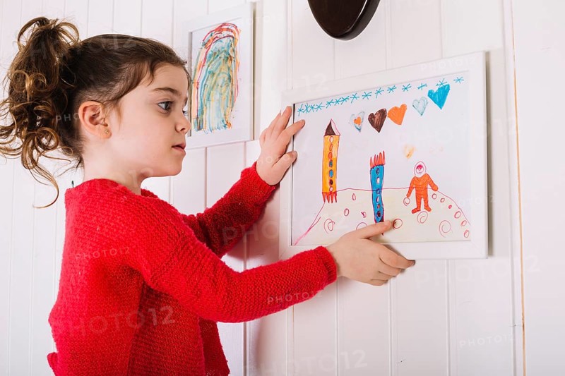 Girl hanging picture frame wall
