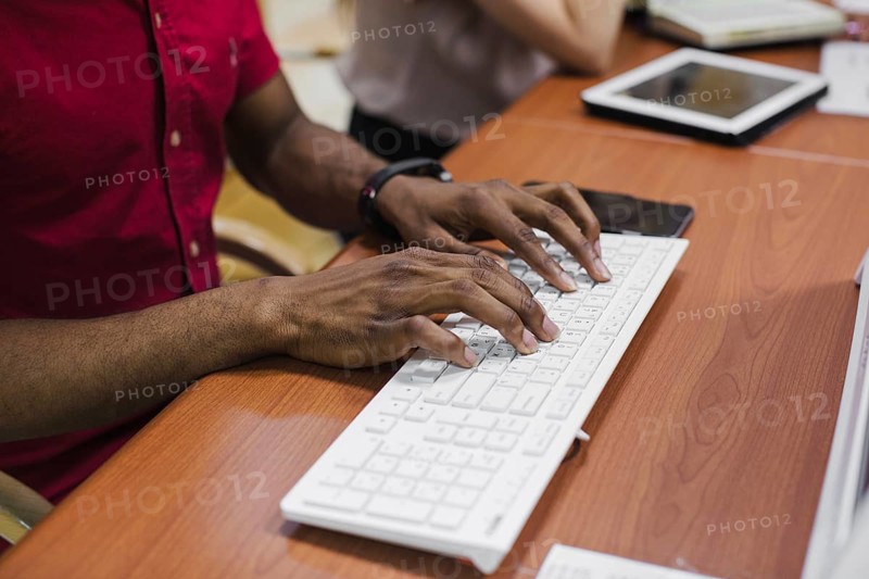 Crop black man typing keyboard