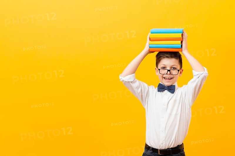 Copy space boy holding stack books