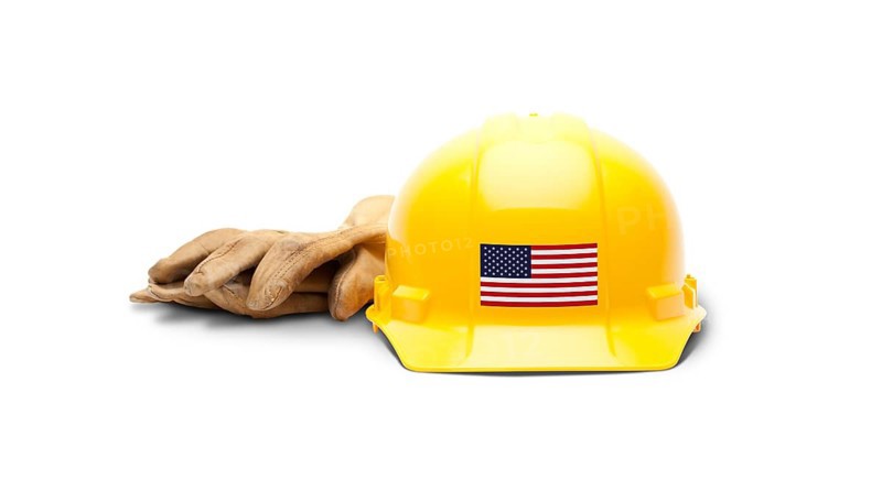 Yellow hardhat with an american flag decal on the front and gloves isolated on white background