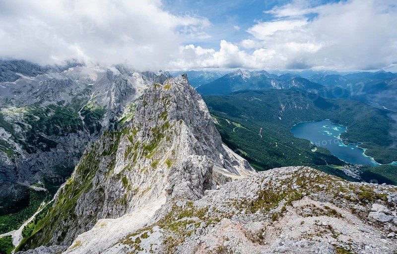 View from the summit of the Waxenstein over the rocky and narrow ridge of the Waxenstein ridge to the Eibsee lake and Hoellental