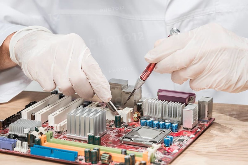 Technician wearing gloves working computer motherboard