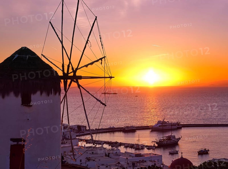 Famous traditional Greek windmill overlook port and harbor of Mykonos