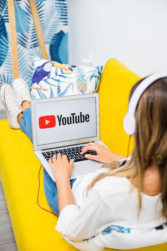 Woman with headphones watching laptop
