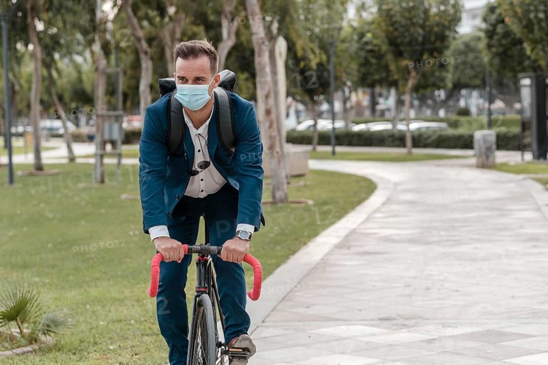 Man riding bike while wearing medical mask