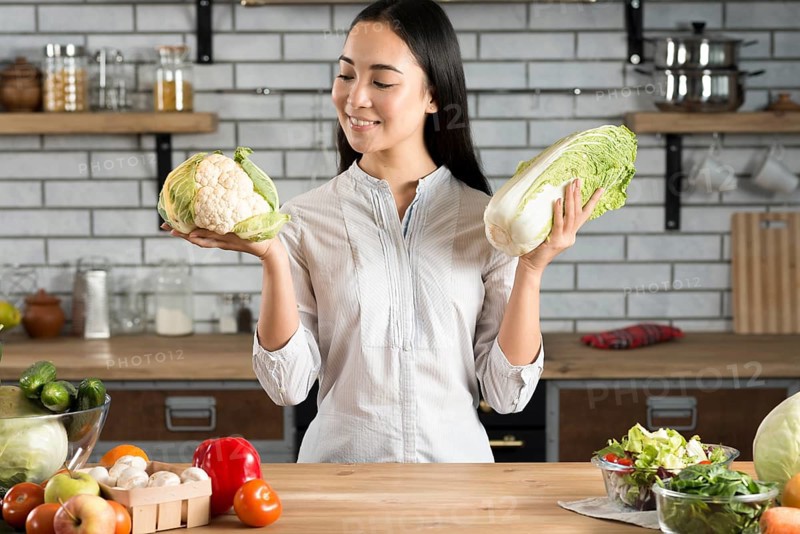 Portrait asian woman holding green cauliflower lettuce kitchen