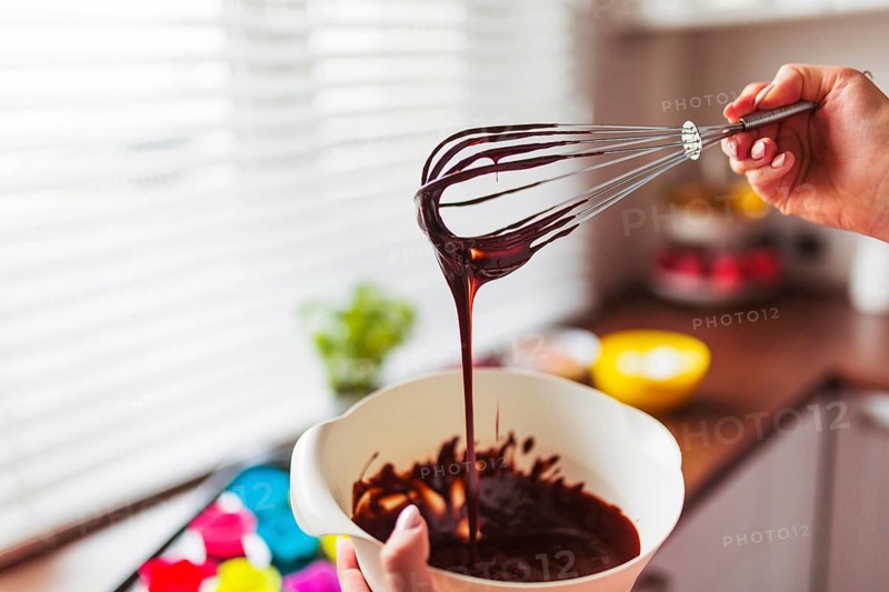 Crop hands mixing batter with whisk