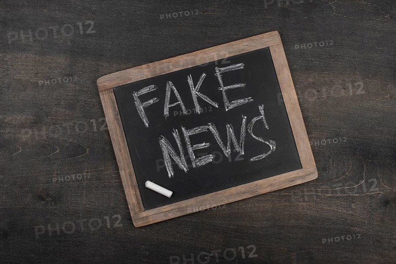 Fake news concept with blackboard top view