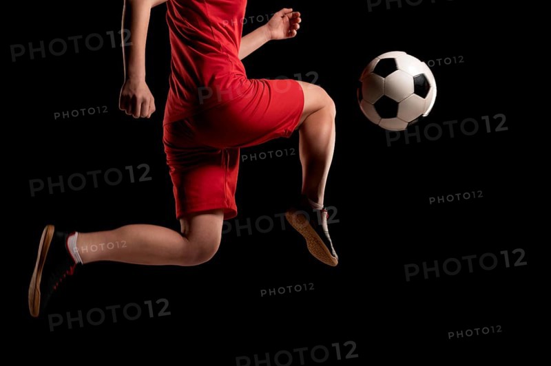Close up woman kicking ball with knee