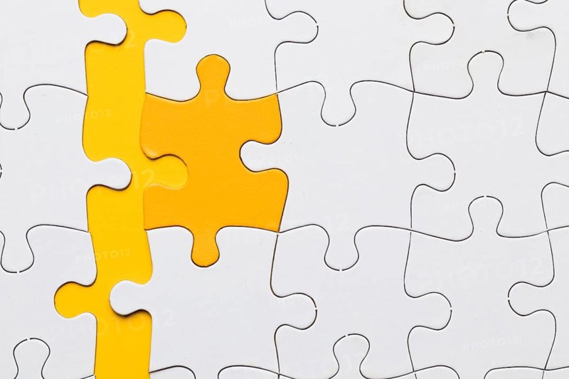 High angle view yellow puzzle piece arranged with white pieces