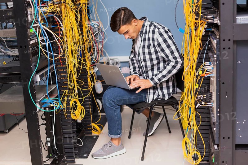 Network engineer with laptop long shot