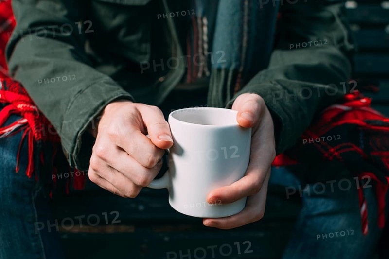 Close up person holding up white mug