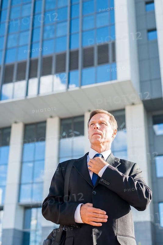 Professional mature man standing front building