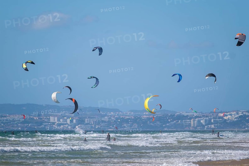 Kiteboarding kitesurfing kiteboarder kitesurfer kites on the Atlantic ocean beach at Fonte da Telha beach