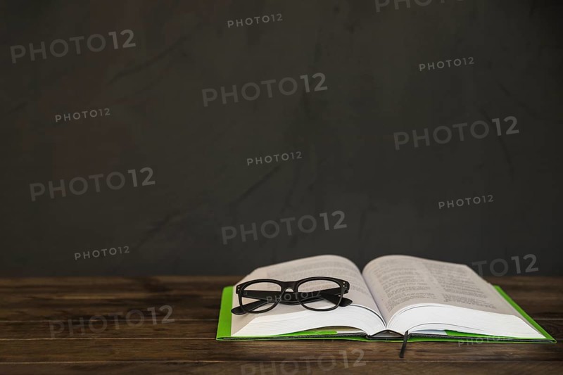 Opened book with glasses table
