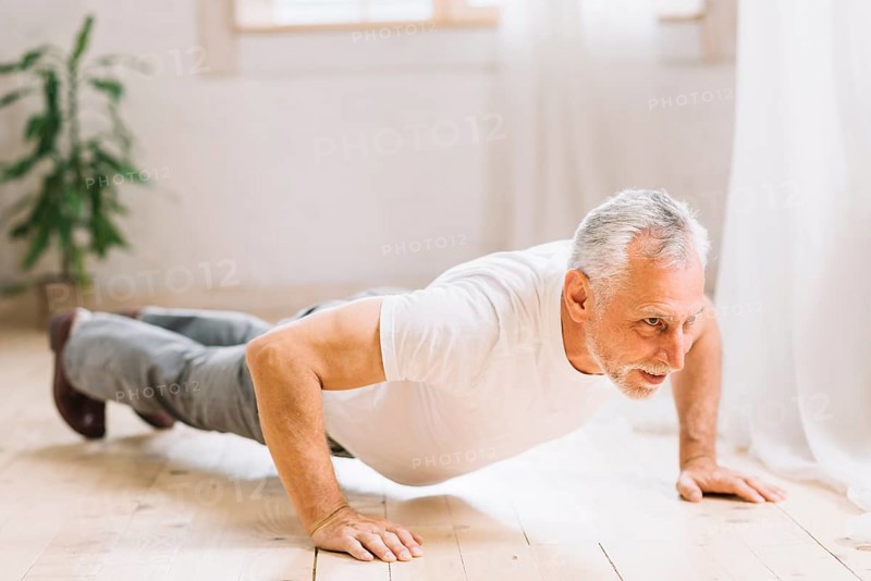Senior man doing pushup exercise hardwood floor