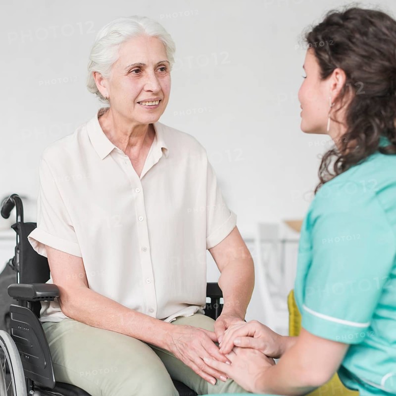 Happy disabled nurse sitting wheel chair looking caretaker