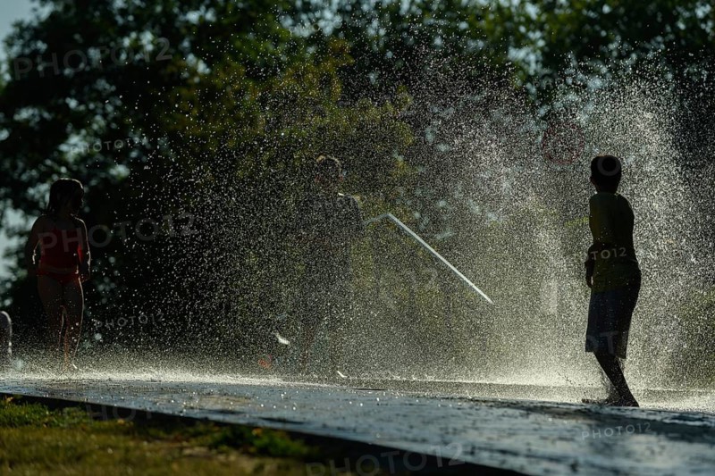 Children playing water in scorching weather in a park. Kehl