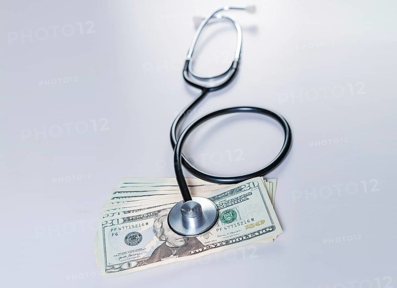 Stethoscope on dollar bills isolated. Stethoscope on top of dollar bills isolated