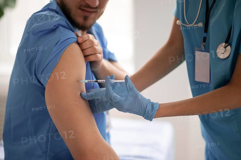 Female doctor vaccinating her colleague