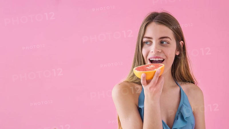Girl bikini eating grapefruit